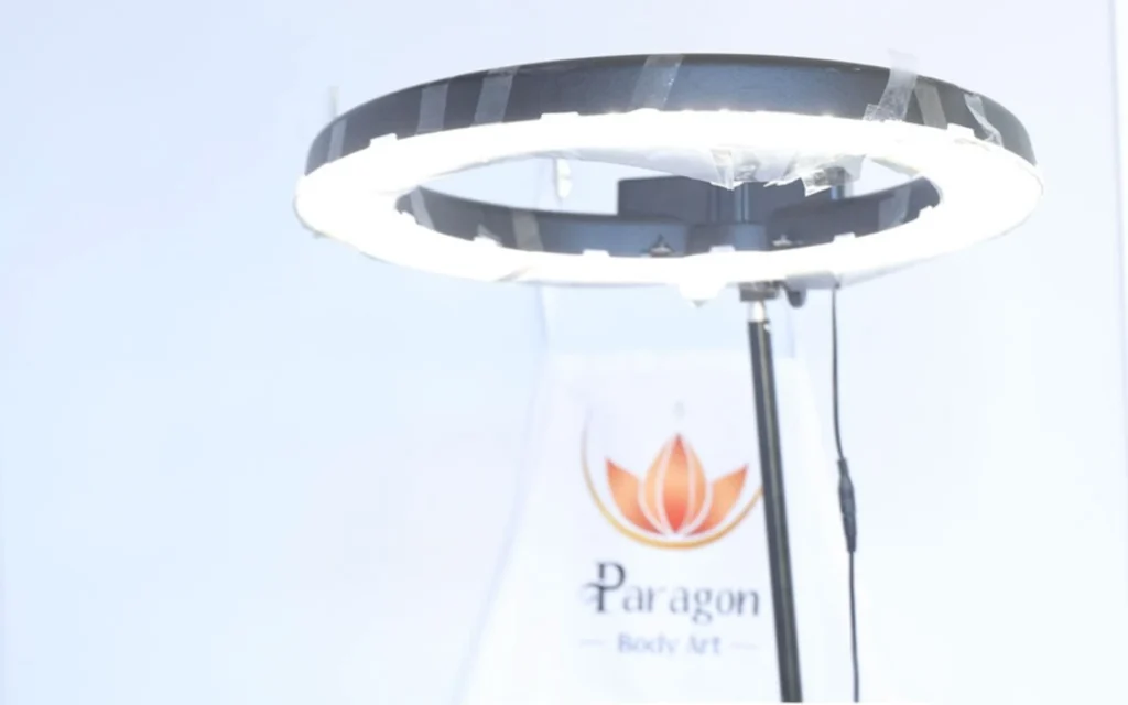 overhead ring light with a Paragon Body Art apron in the background